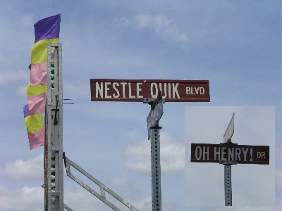 [Two signs (one small image placed atop another-each with one sign) which read Nestle Quik Blvd and Oh Henry! Dr.]